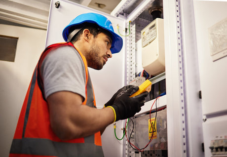 Person in safety gear working on electrical equipment